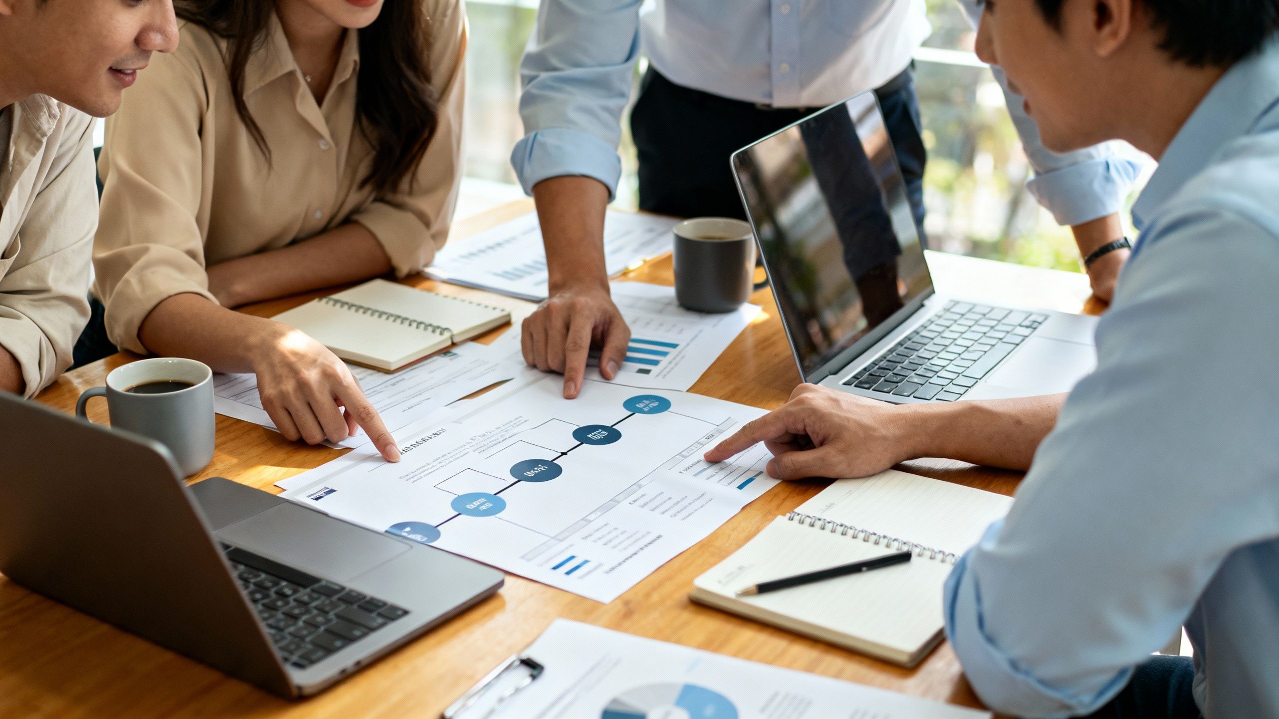 Small business team reviewing sales pipeline and client communication workflow around a desk