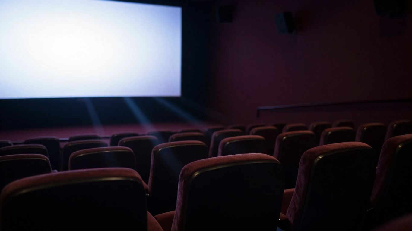 Interiorul unei săli de cinema goale, cu ecranul aprins.