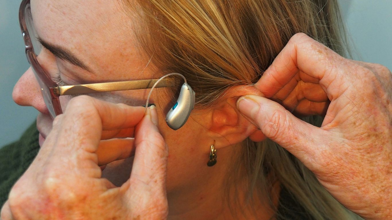 a woman is putting on a pair of glasses