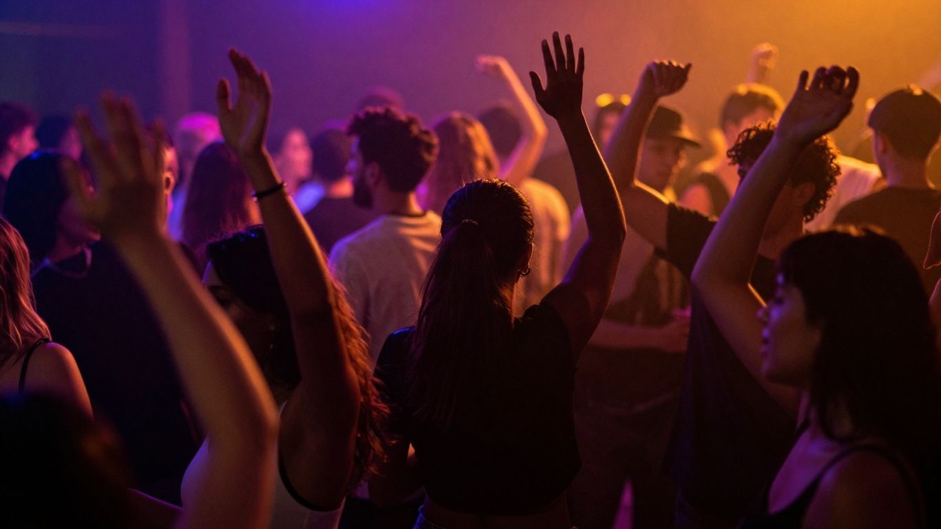 Dansende menigte onder discobal en felle lichten.