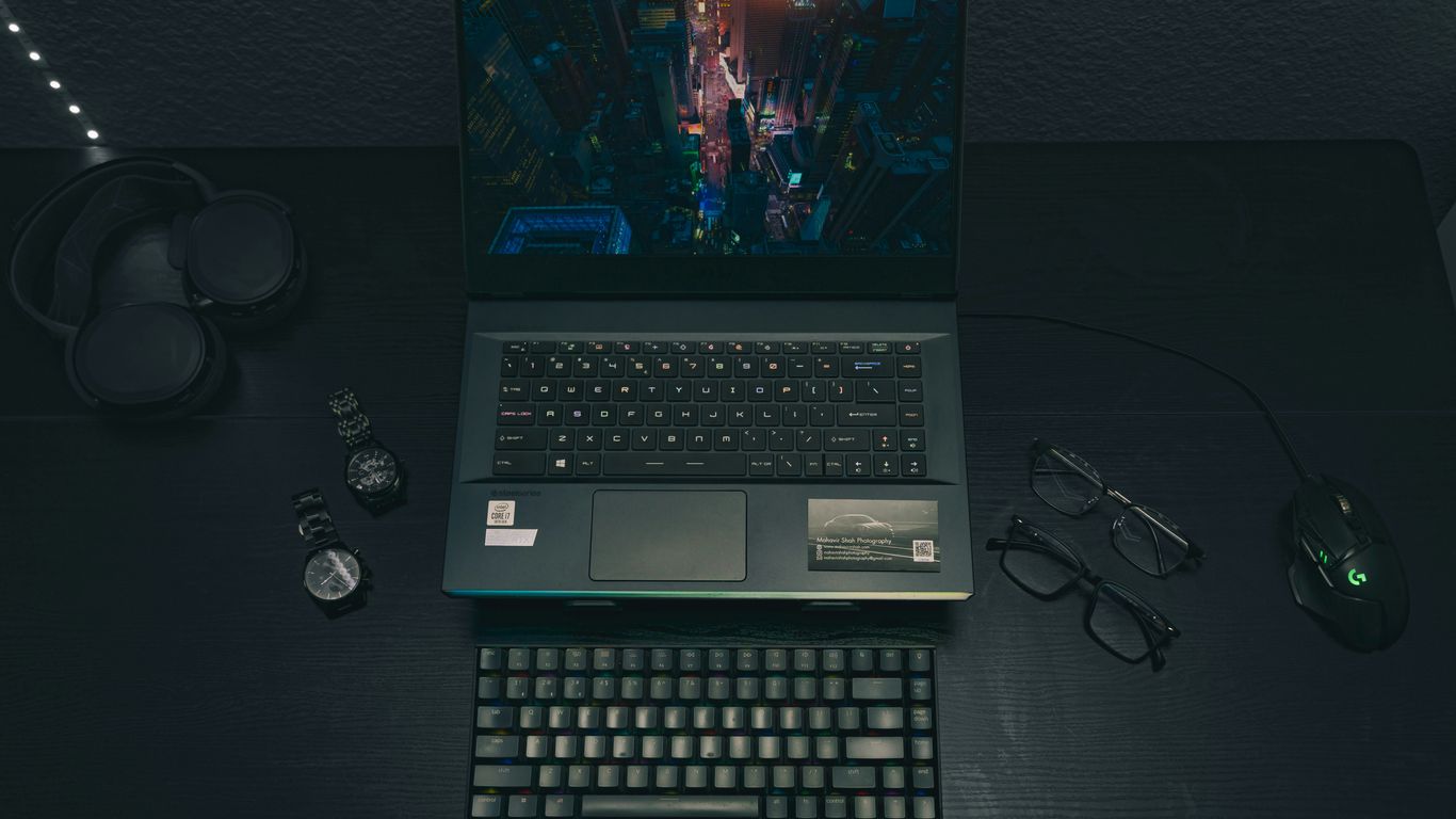 a laptop computer sitting on top of a wooden desk