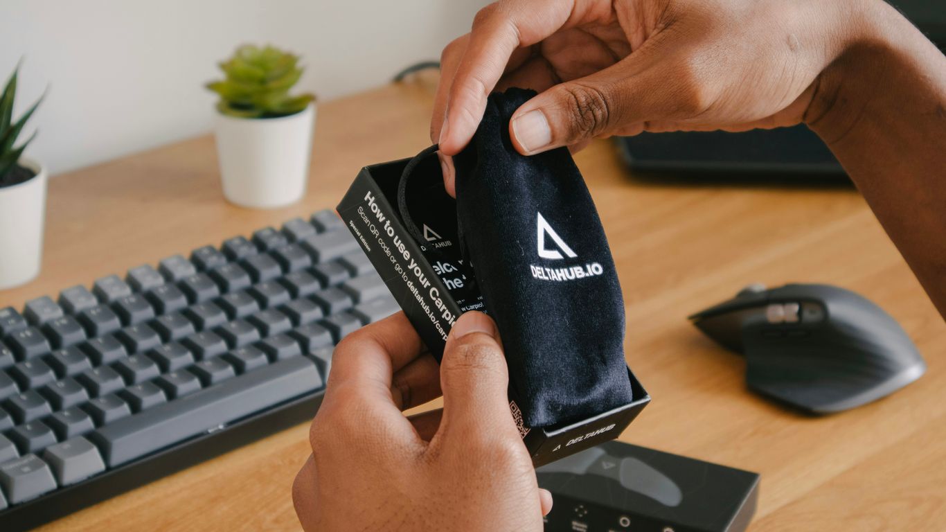 person holding black and white adidas pouch