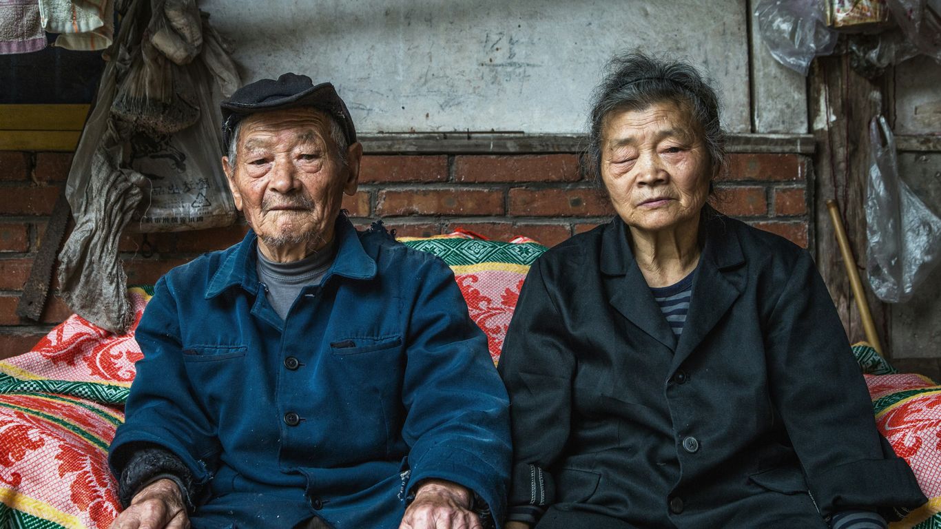 senior couple sitting on sofa beside wall