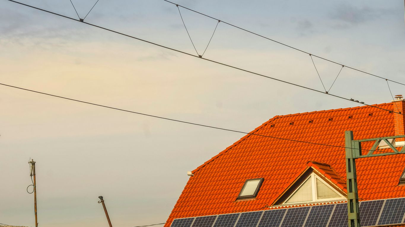 Orange roof with solar panels and overhead wires