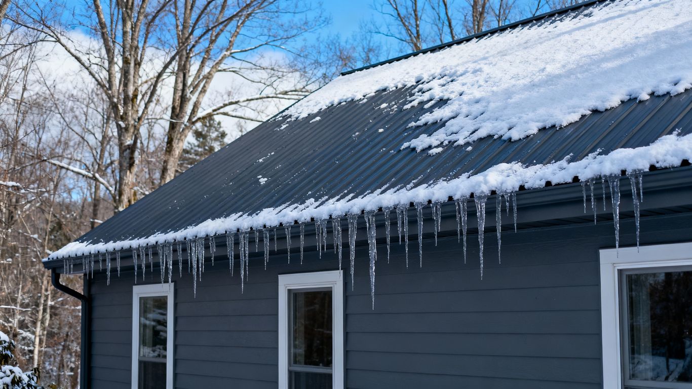 Steel roof on a snowy house in winter.