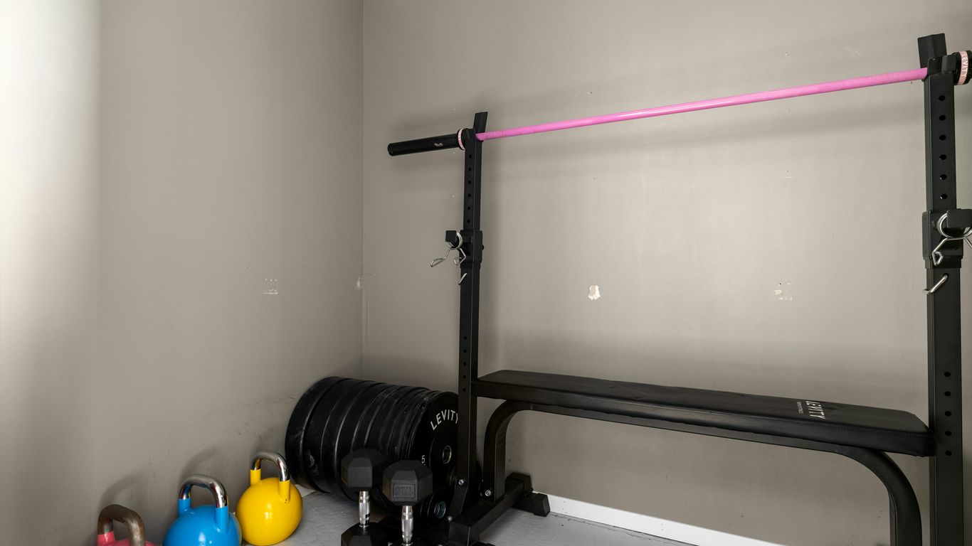 A gym room with a row of exercise equipment