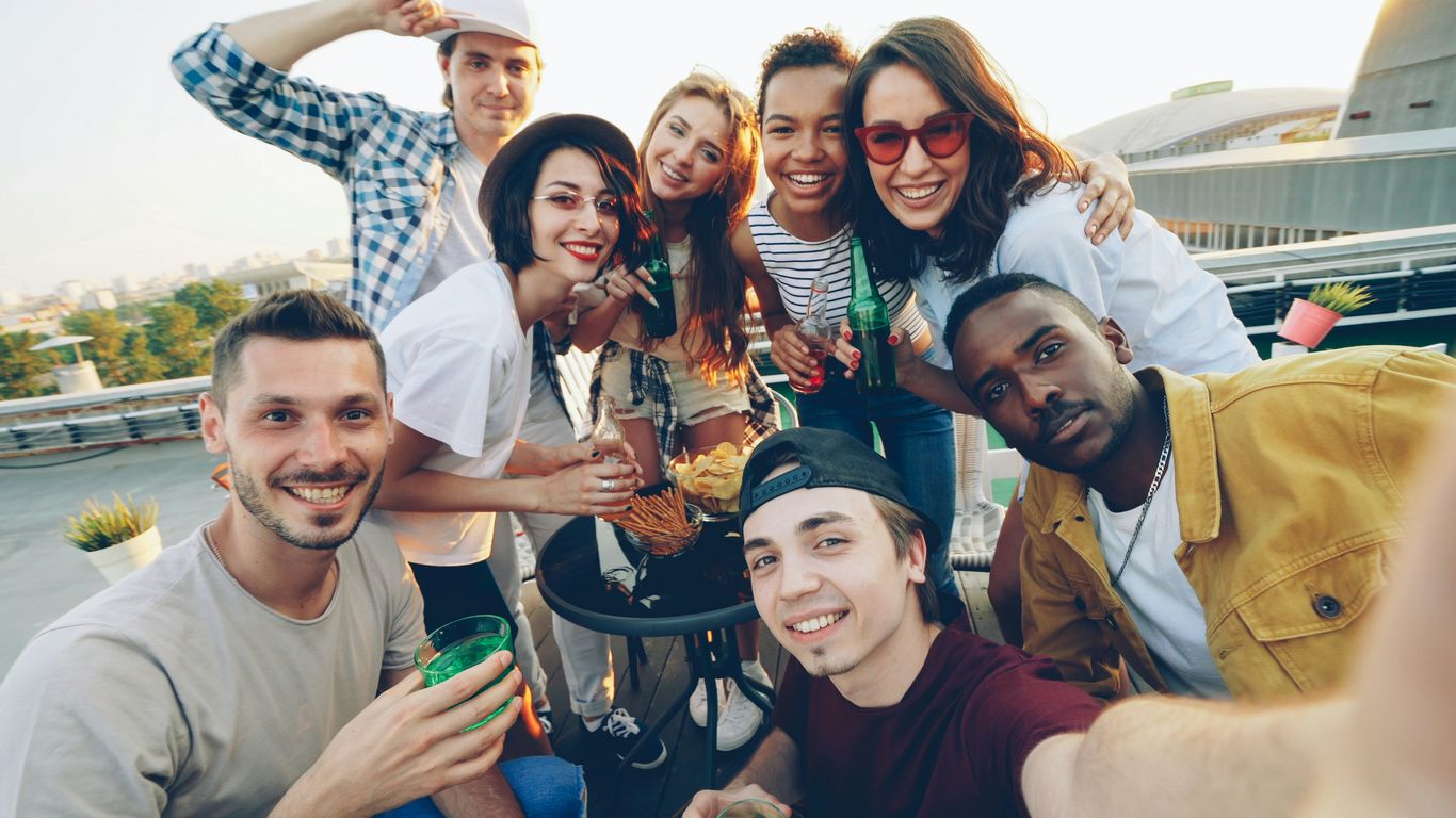 Diverse group of friends taking a selfie on a rooftop.