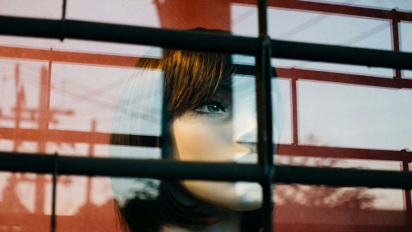 a mannequin's head is seen through a window