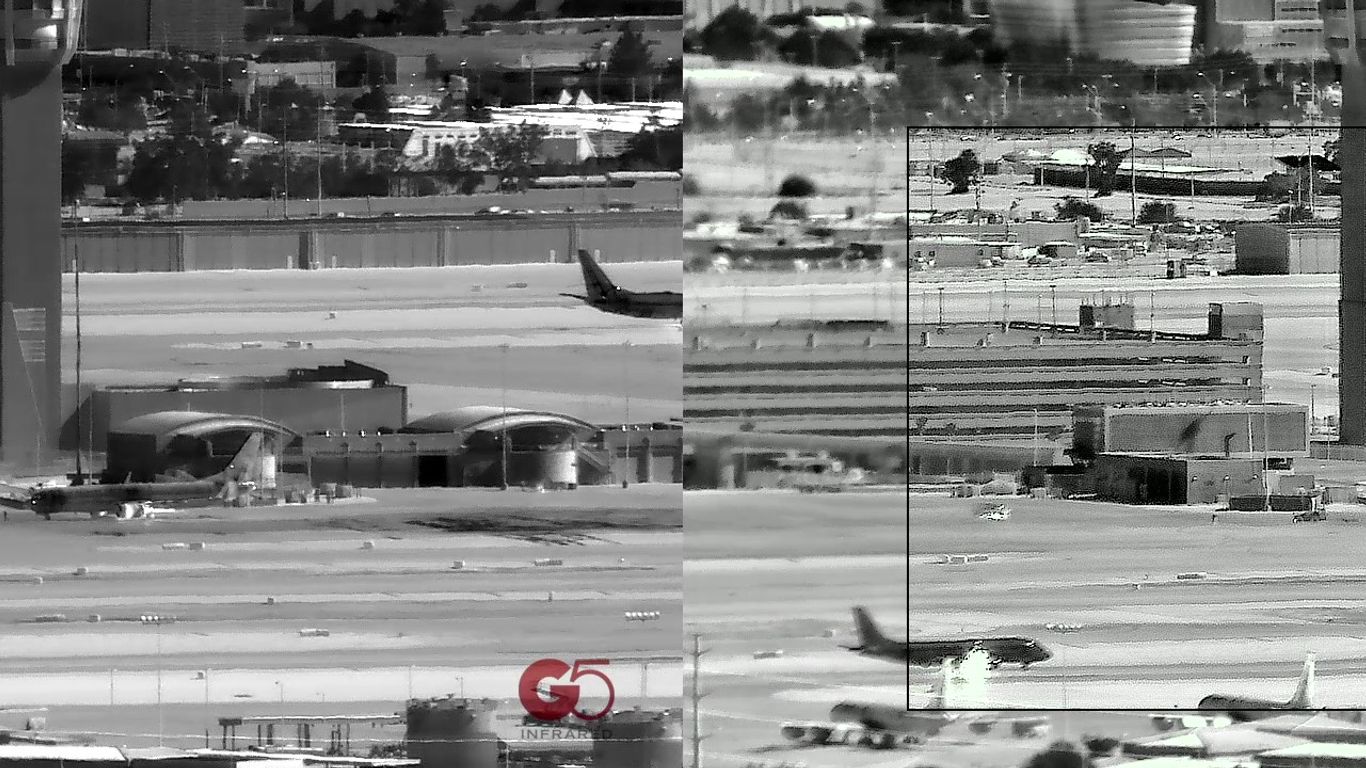 Airport scene with airplanes, control tower, and buildings in infrared.