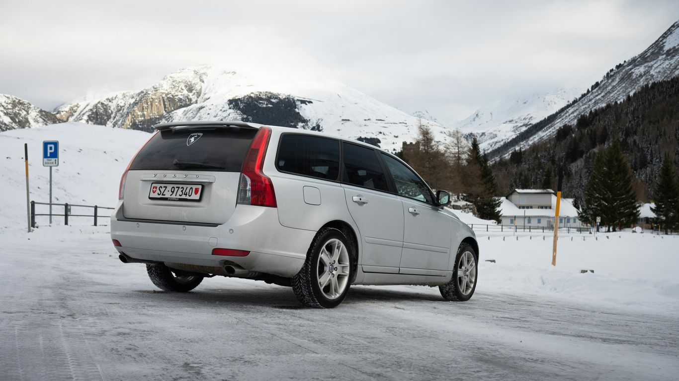 Silver volvo station wagon parked in snowy mountain landscape