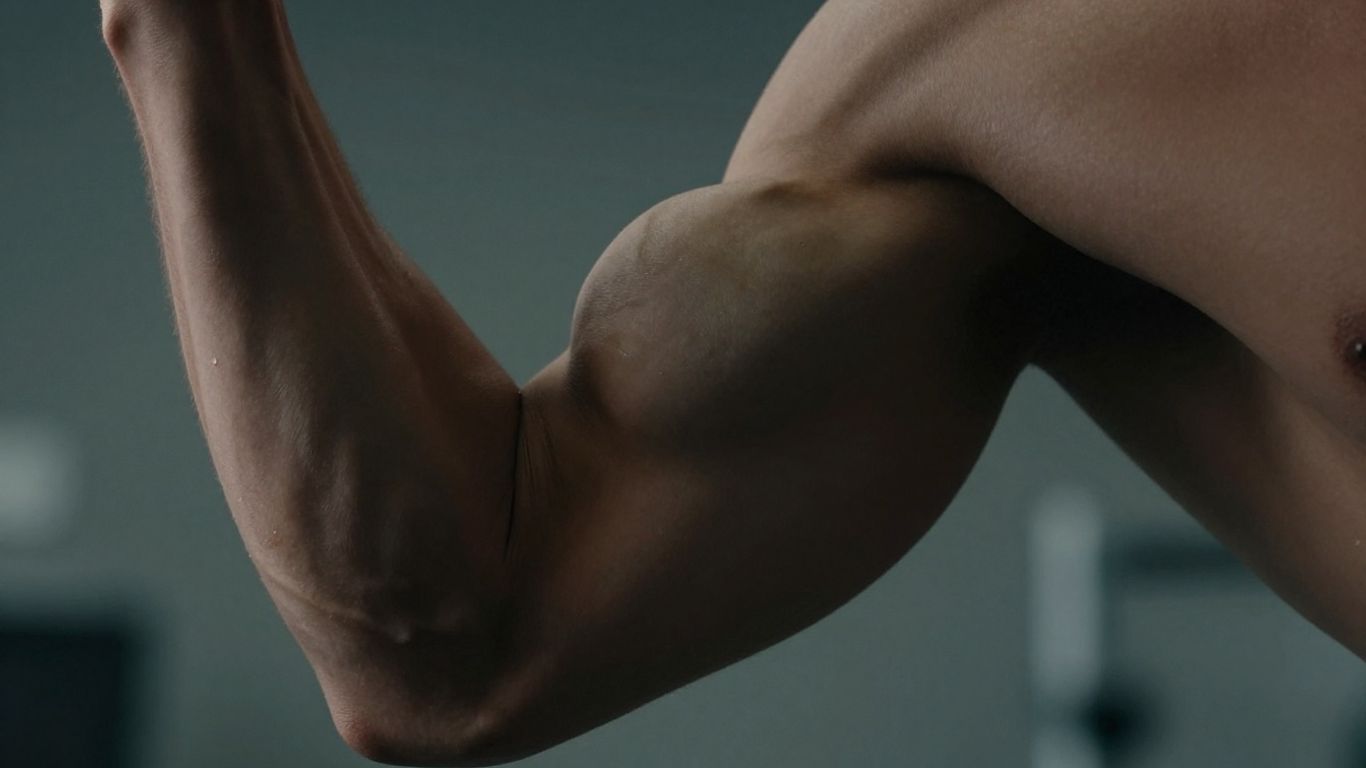 Muscular arm flexing, dramatic lighting, research context.