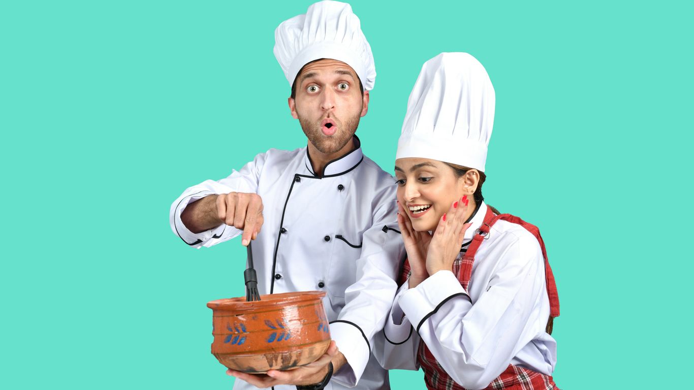 a man and a woman wearing white hats and holding a bucket
