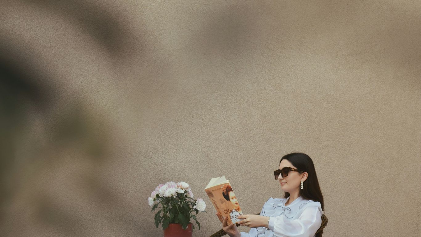 a person sitting at a table reading a book