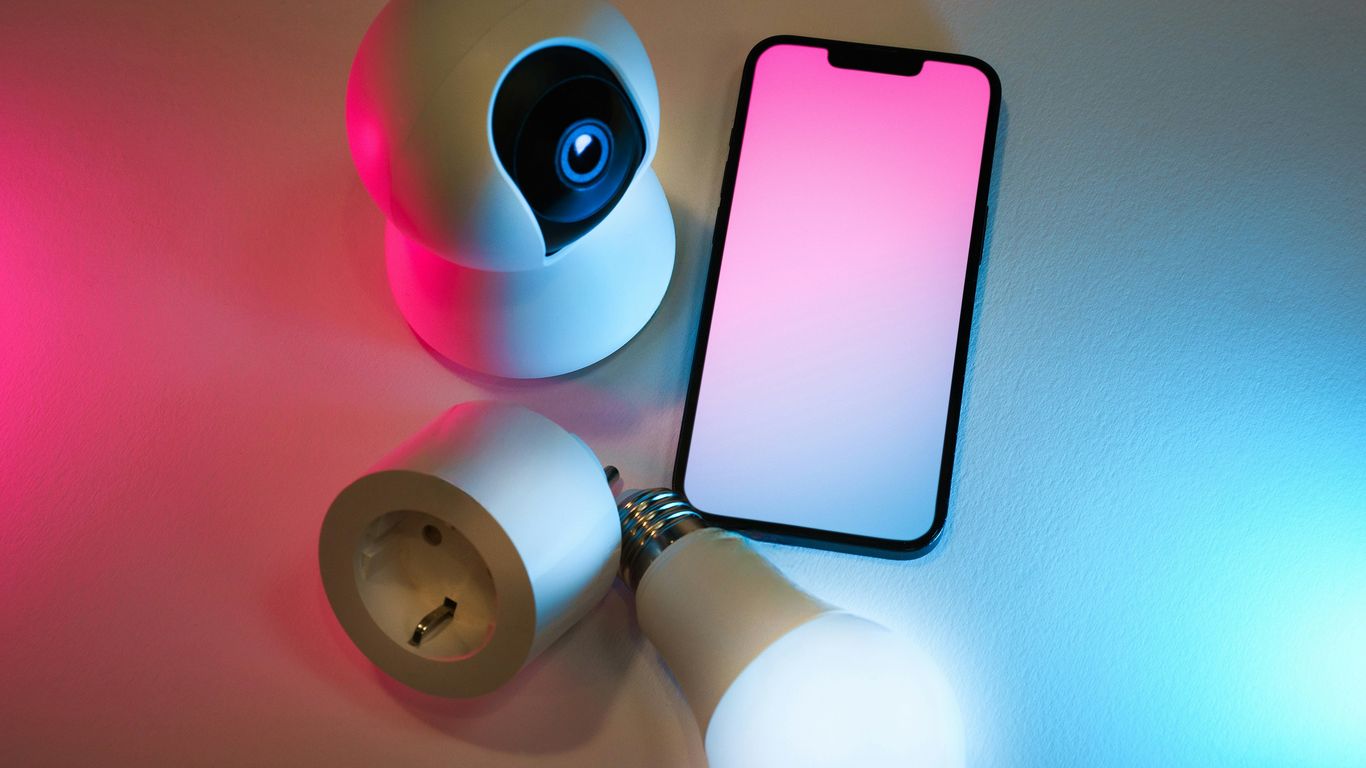 A smart phone sitting on top of a table next to a flashlight