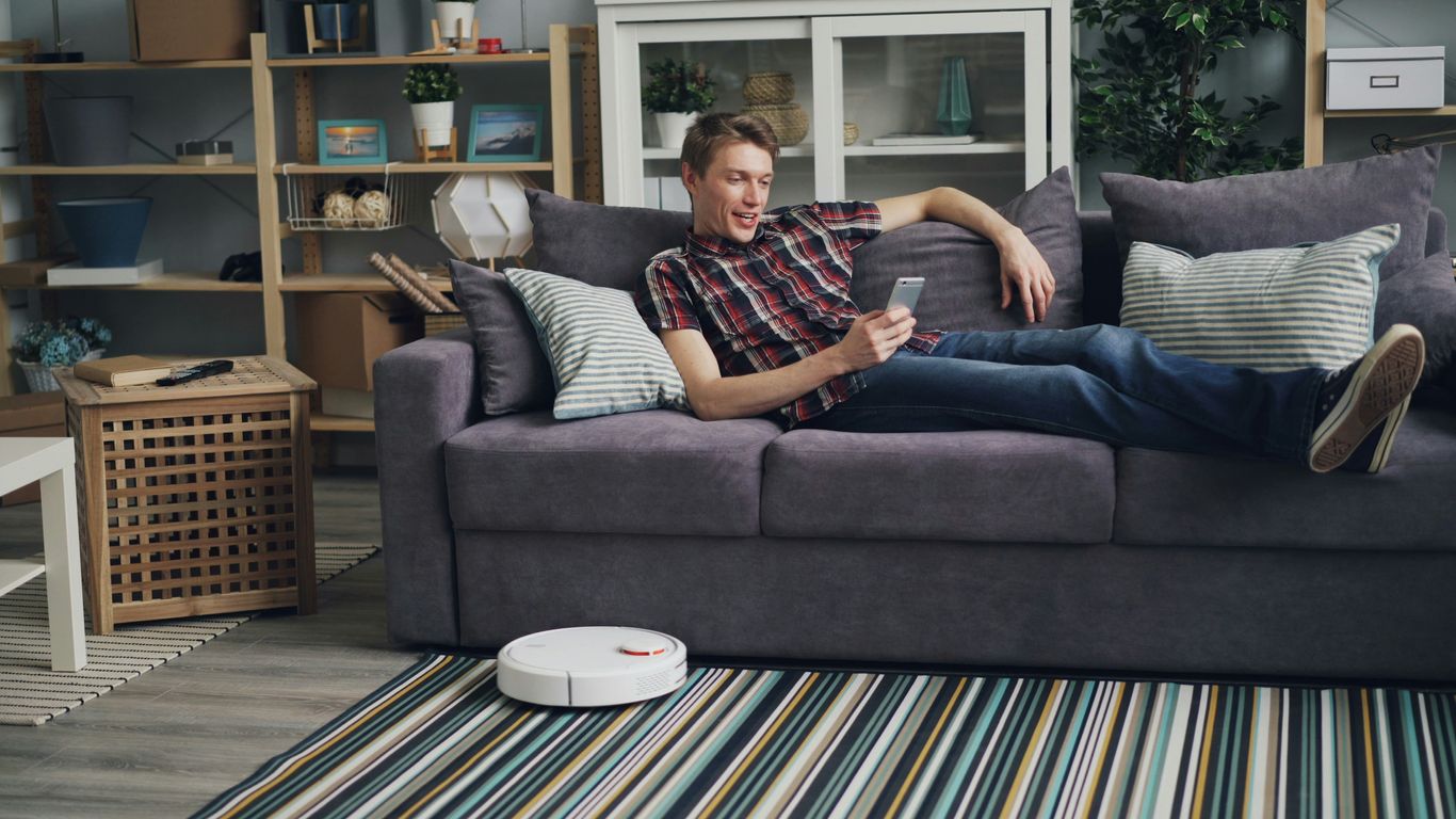a man laying on a couch with a remote control