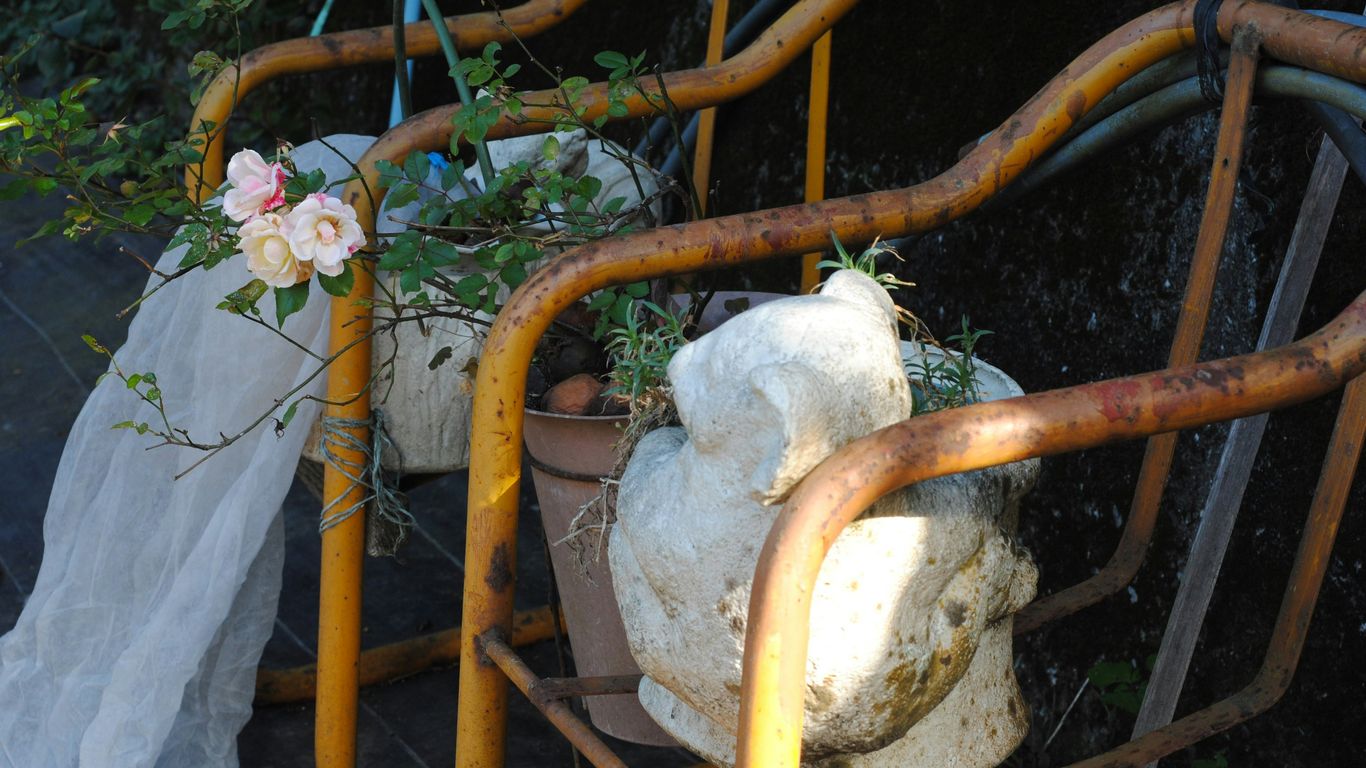 A rustic swing set adorned with flowers.