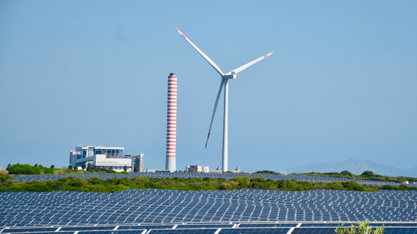 A wind farm with a wind turbine in the background