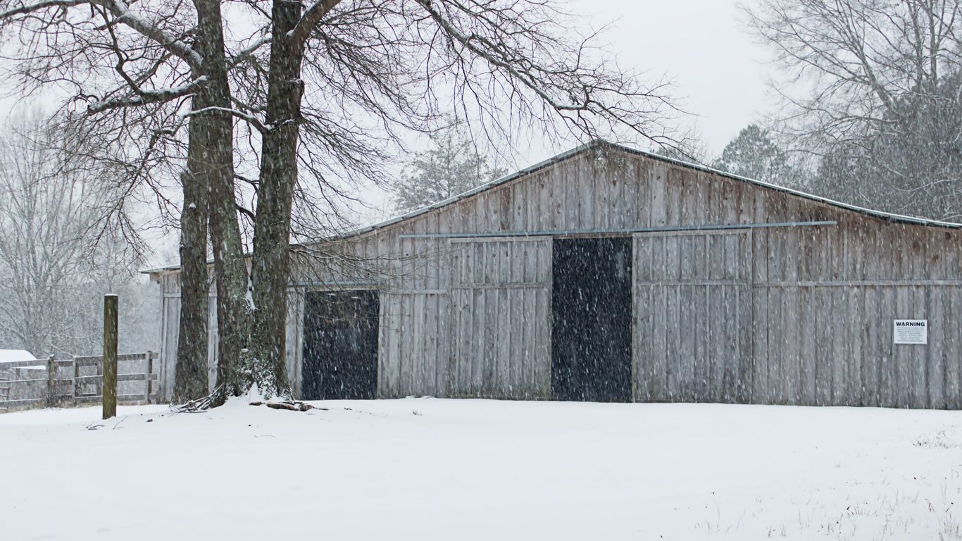 A barn in the middle of a snowy field