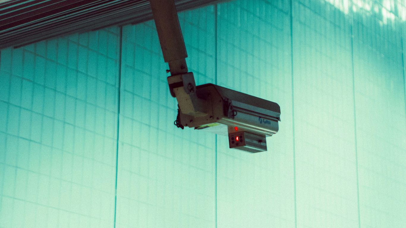 a security camera mounted to the side of a building
