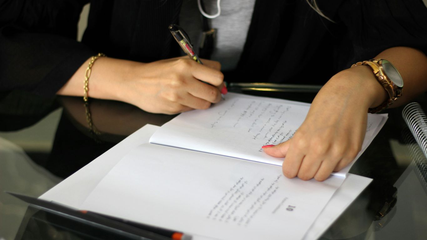 a person writing on a piece of paper