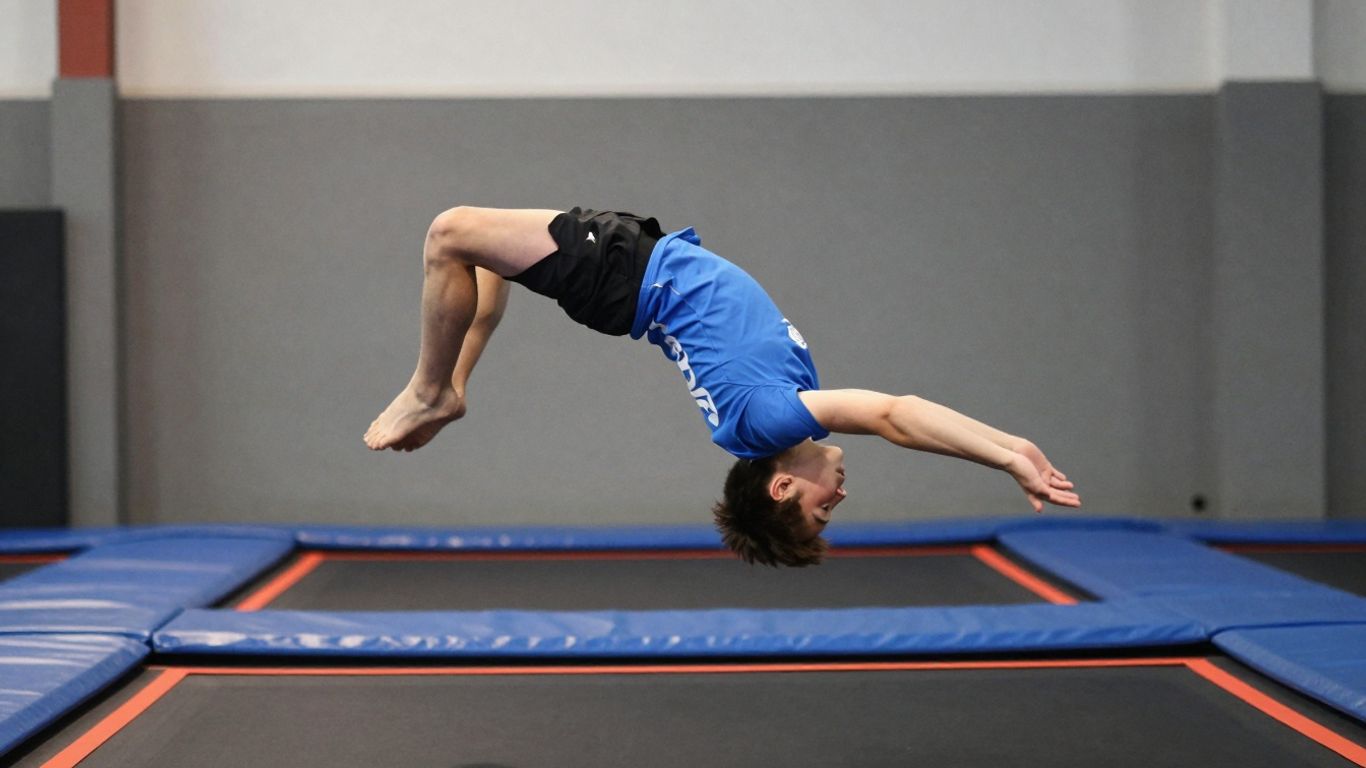 Beginner performing a trampoline backflip mid-air.
