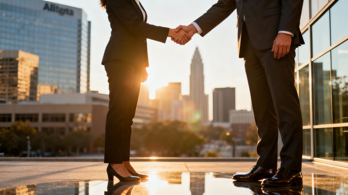 Business handshake with Atlanta skyline background.
