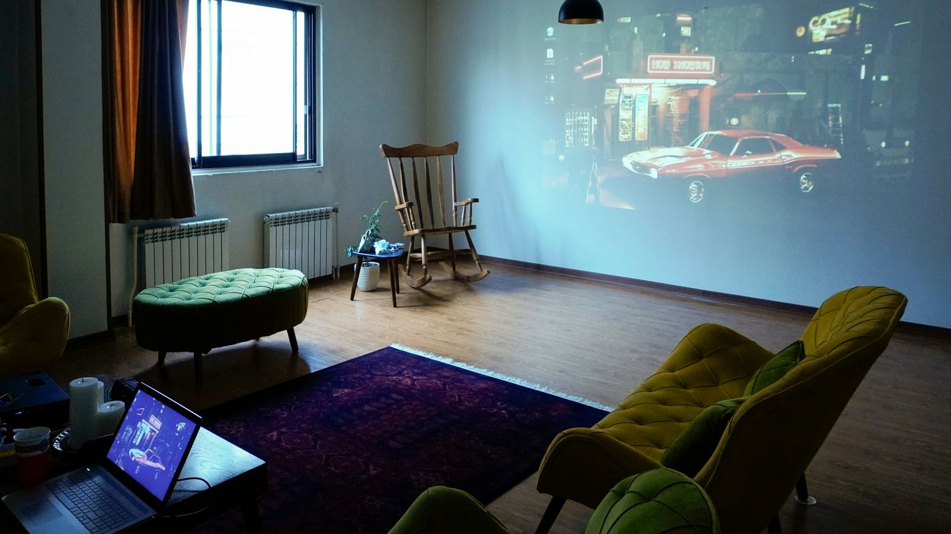 A film is projected on a white wall.