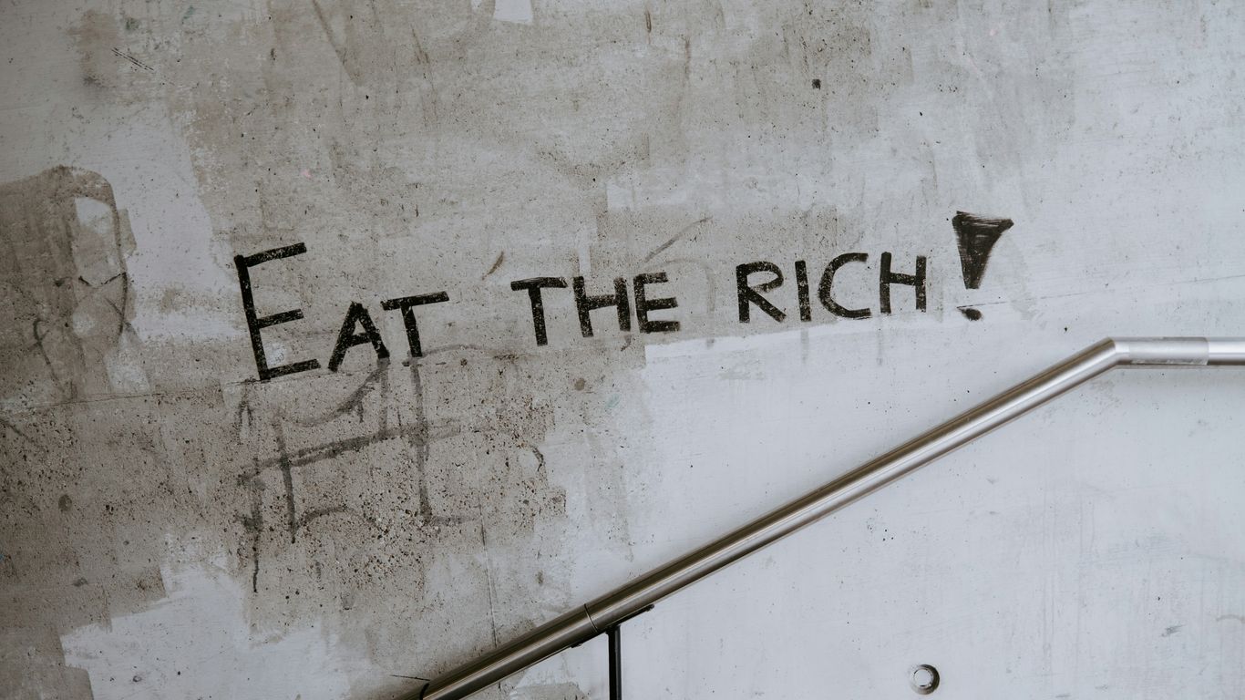 graffiti on a wall that says eat the rich