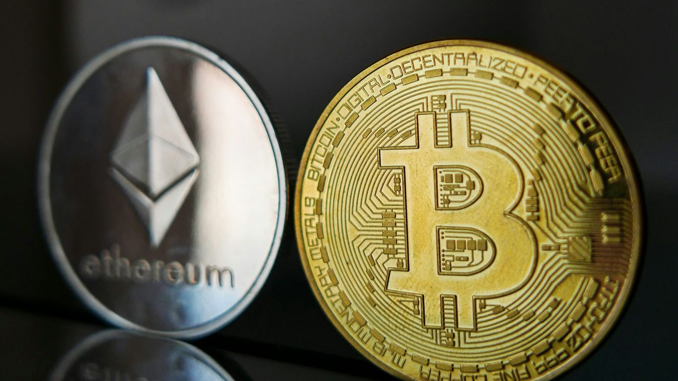 Two cryptocurrency coins, one silver (Ethereum) and one gold (Bitcoin).