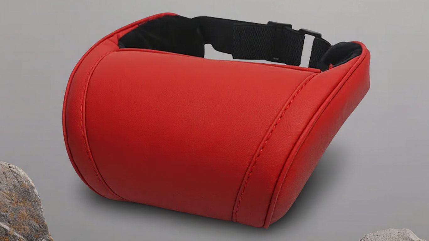 Red neck pillow on a neutral background with rocks.