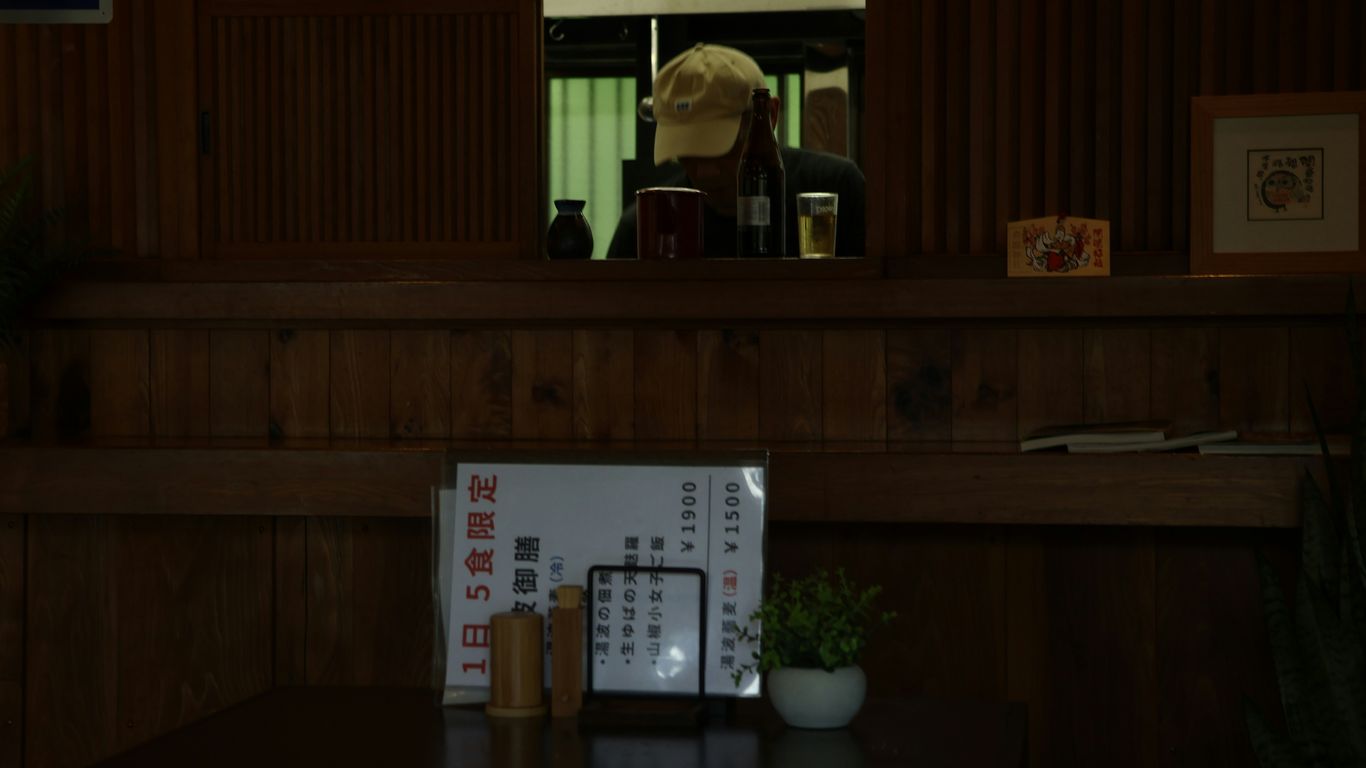 A dark restaurant scene with a person in the back.