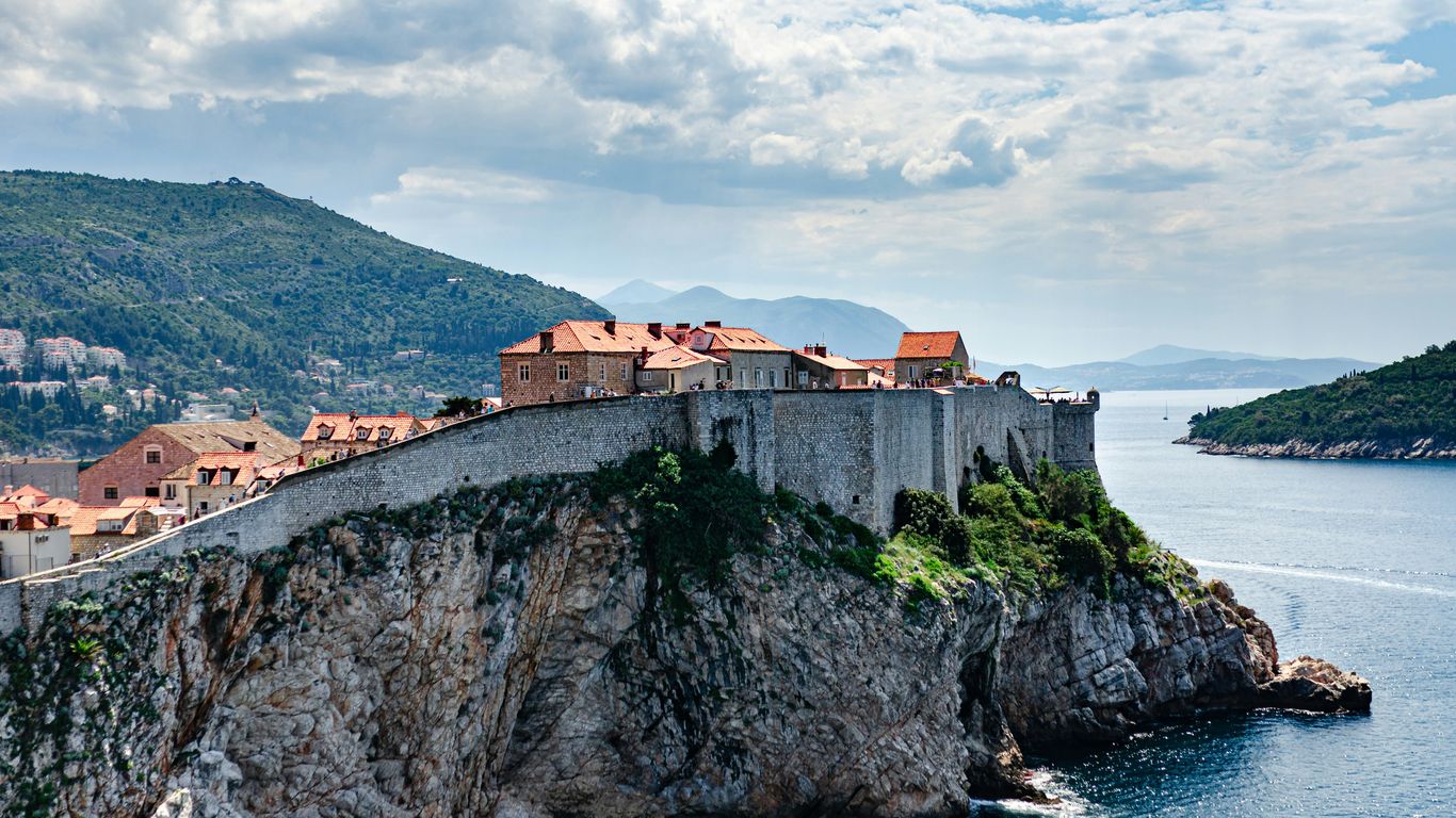 a castle on a cliff overlooking a body of water