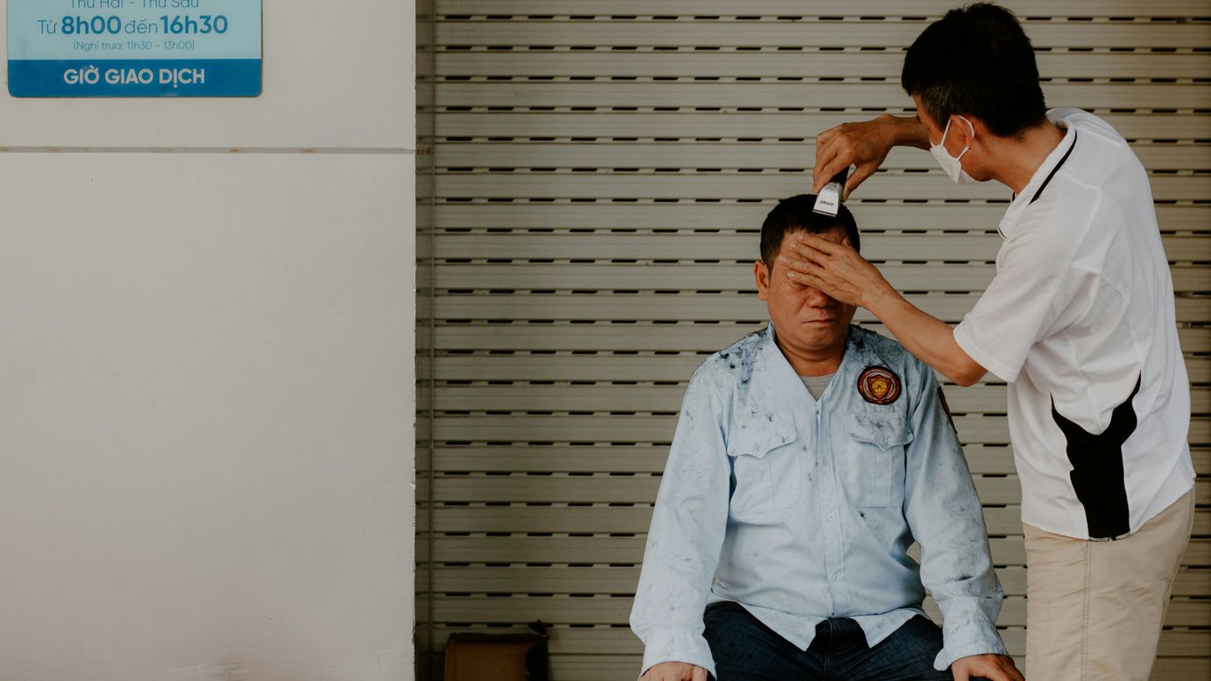 a man sitting on the floor with another man standing by him