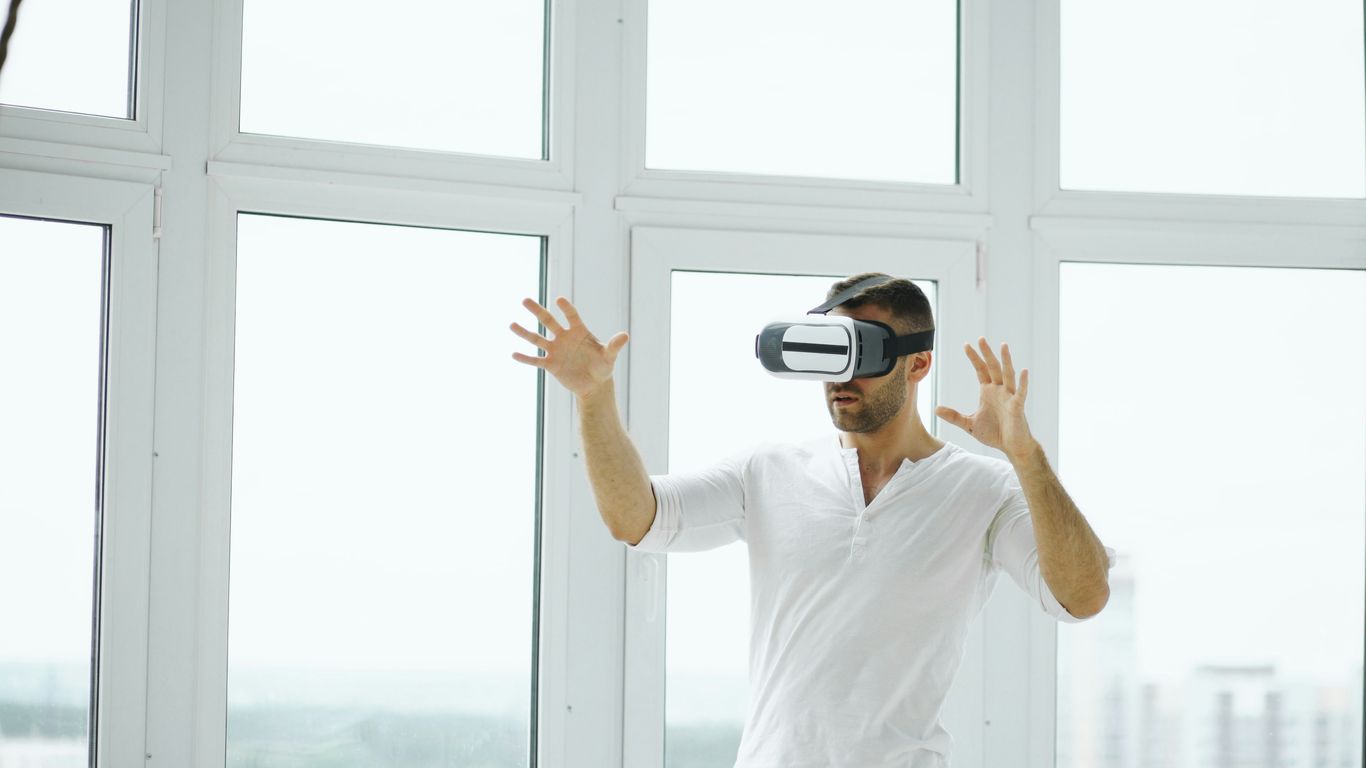 Man wearing vr headset with hands outstretched.