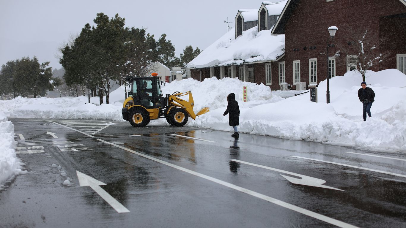 a tractor is parked on the side of the road in the snow