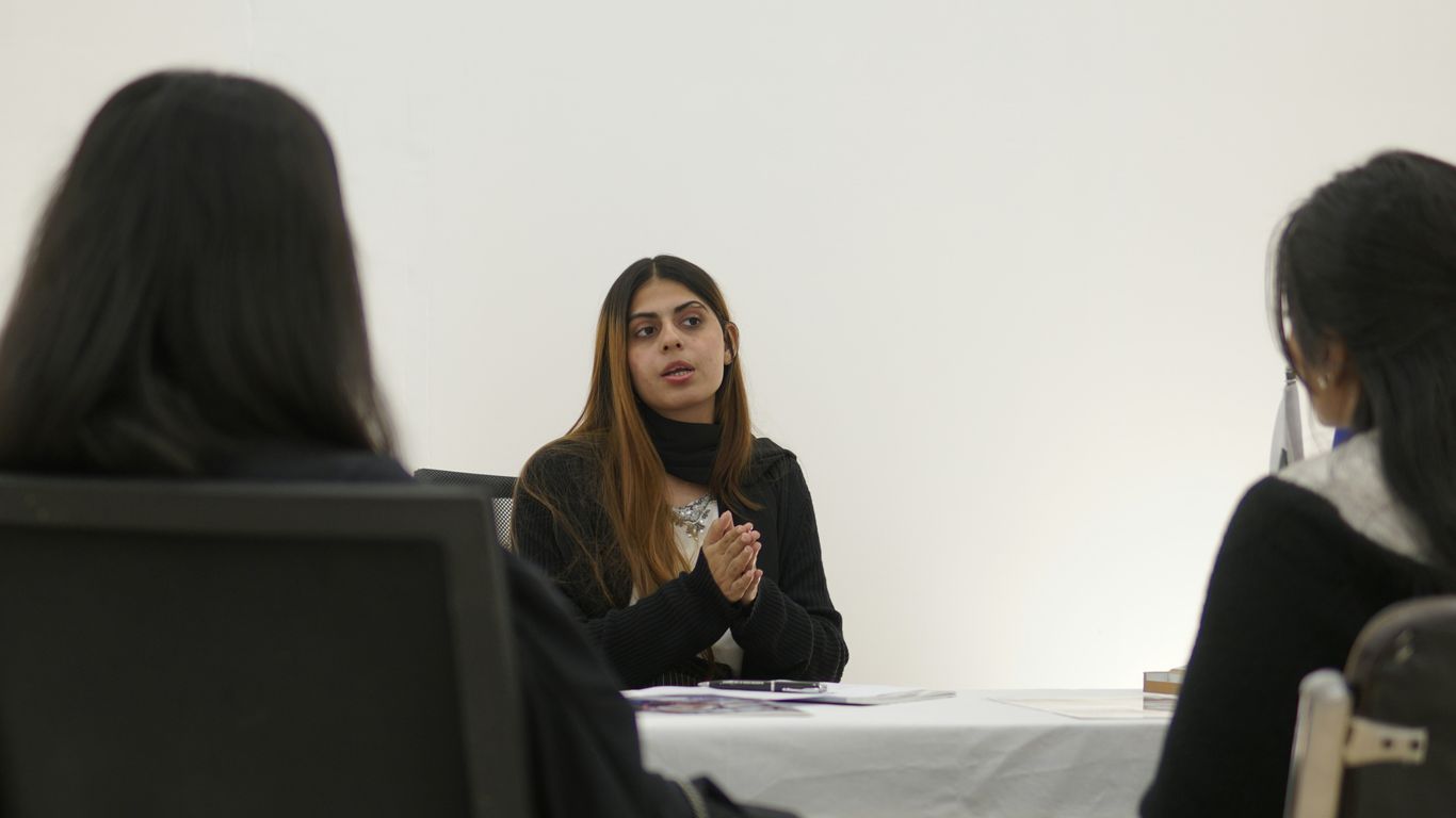 Woman speaking to two people across table