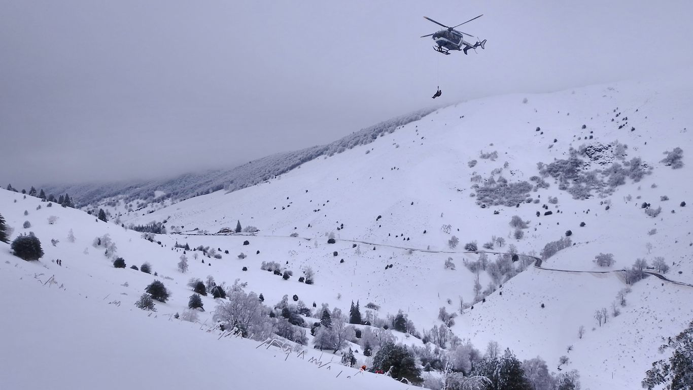 a helicopter flying over a snow covered mountain