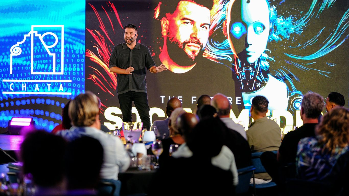 Man presents on stage with robot graphic background