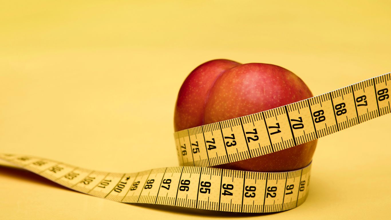 red apple fruit with tape measure