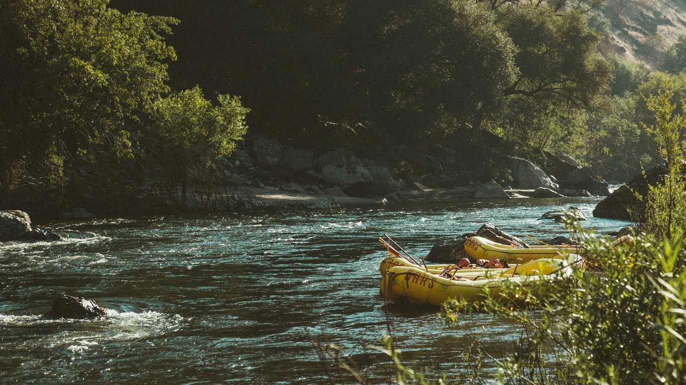 two yellow inflatable boats beside river at daytime