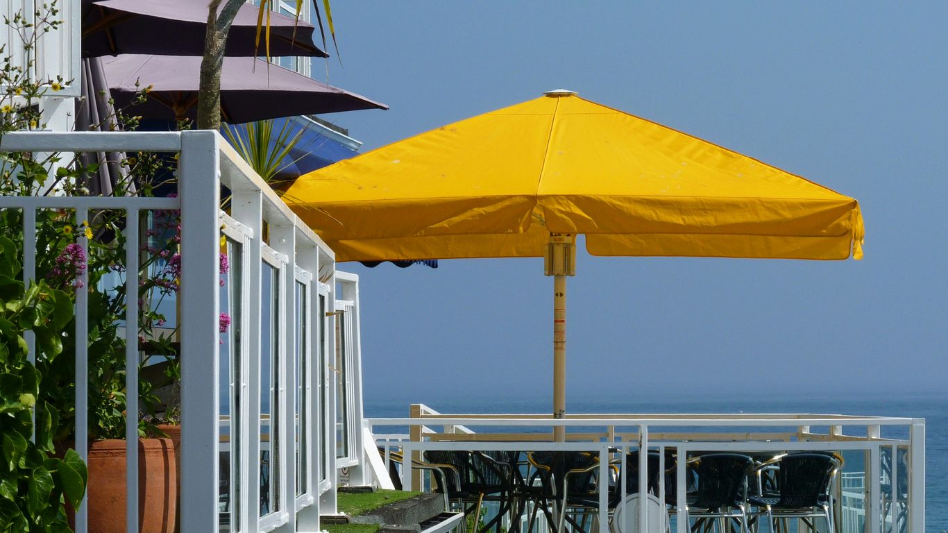 a yellow umbrella sitting on top of a wooden deck