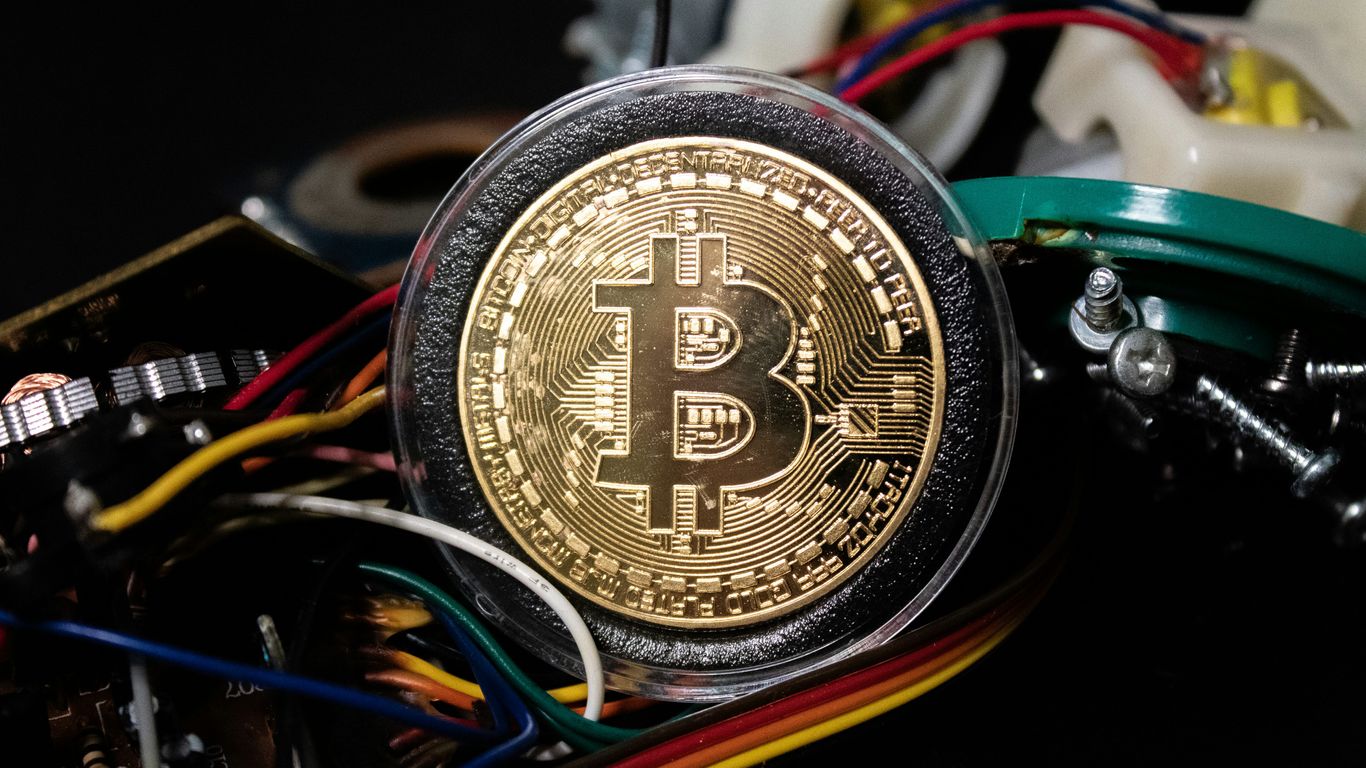 A Bitcoin coin surrounded by colorful electronic components and wires.