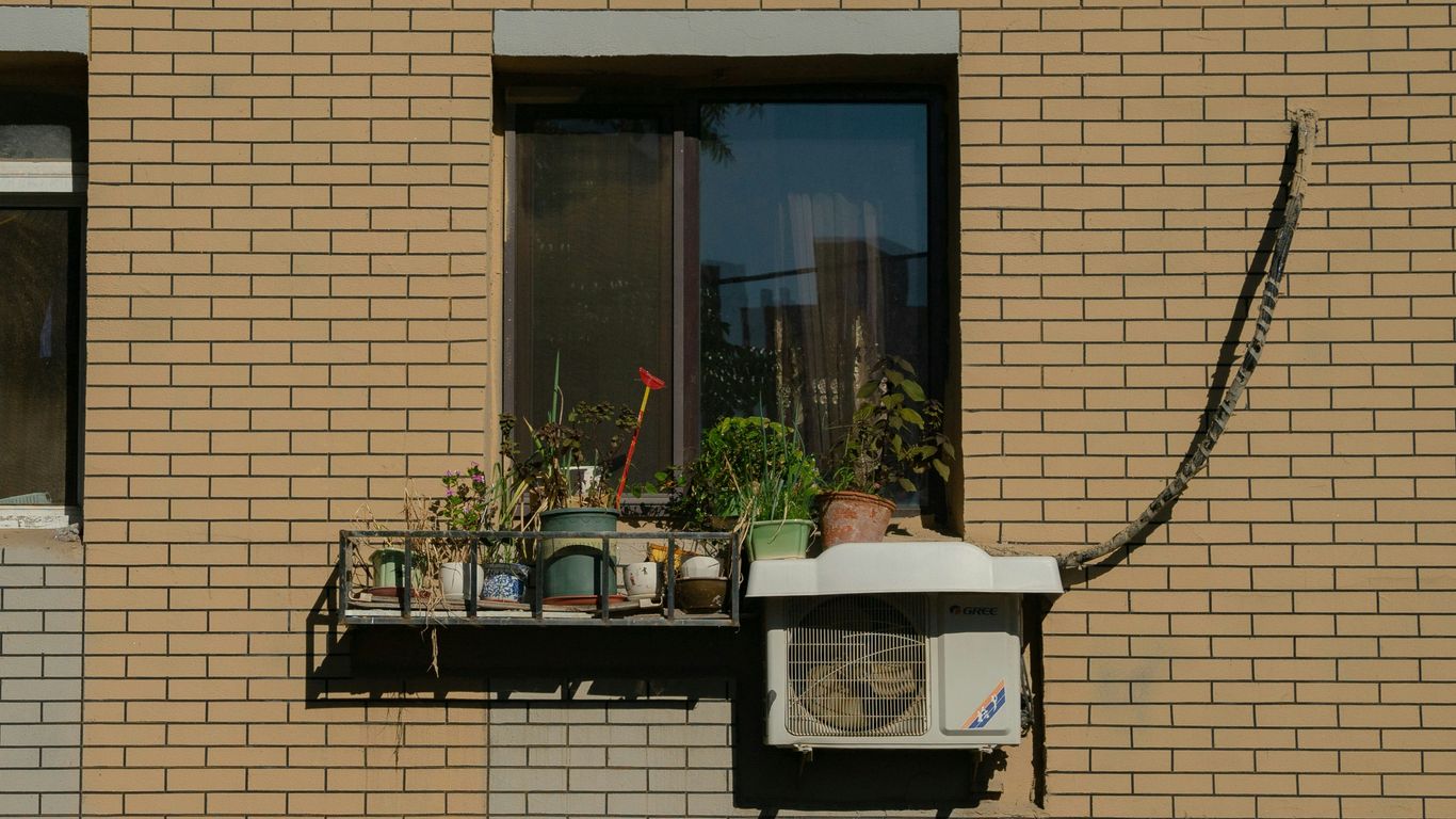 a brick building with a window and a small air conditioner in front of it