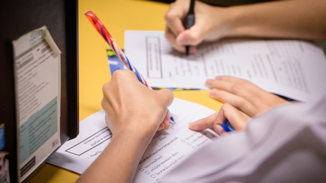 person writing on white paper