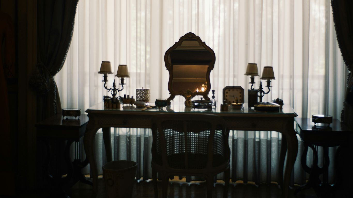 Elegant vanity table with mirror and lamps.