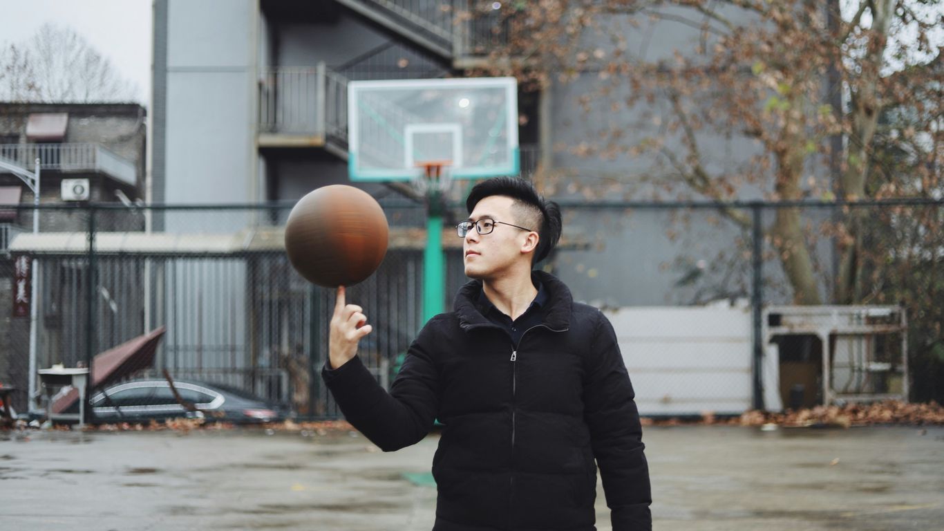 man standing and playing with basketball ball