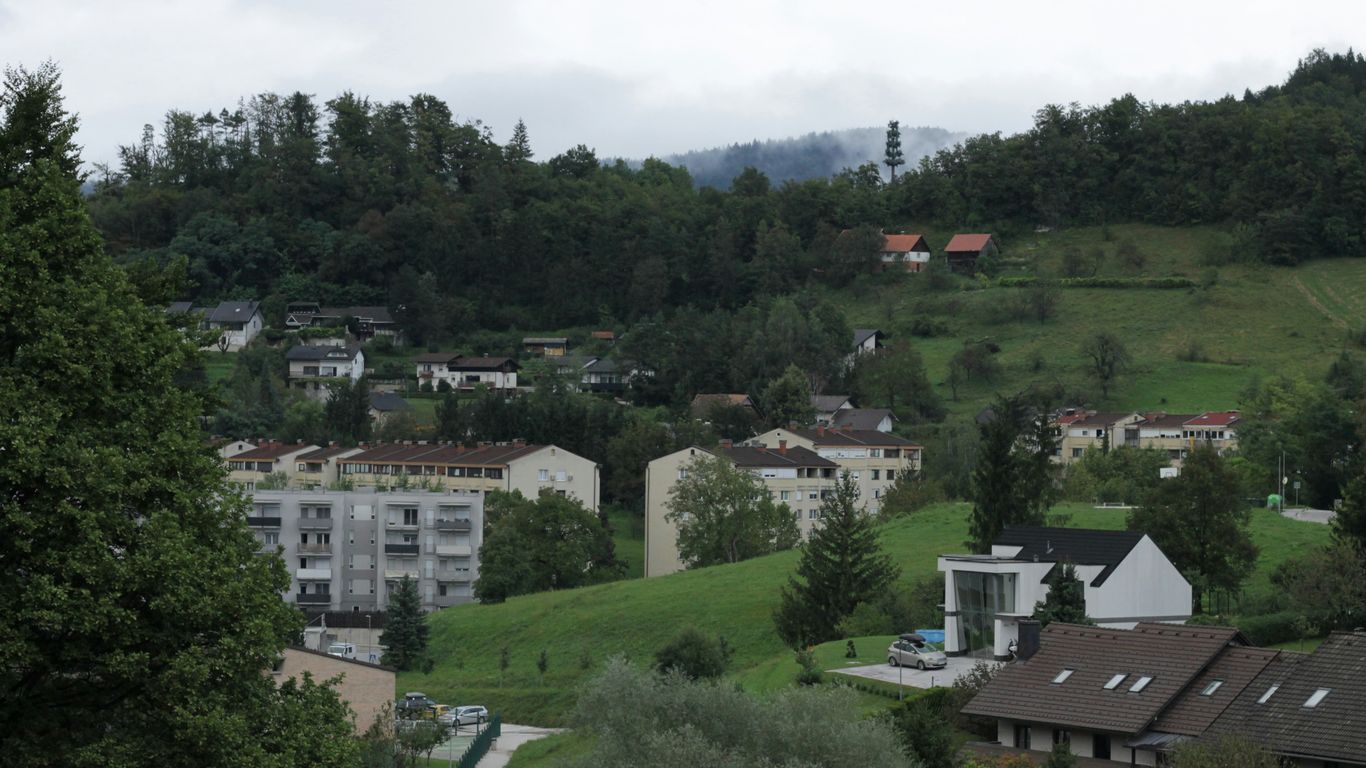Houses and buildings are nestled in a green valley.