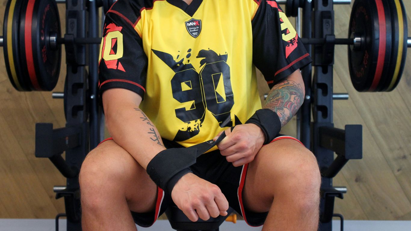 a man sitting on top of a bench in a gym