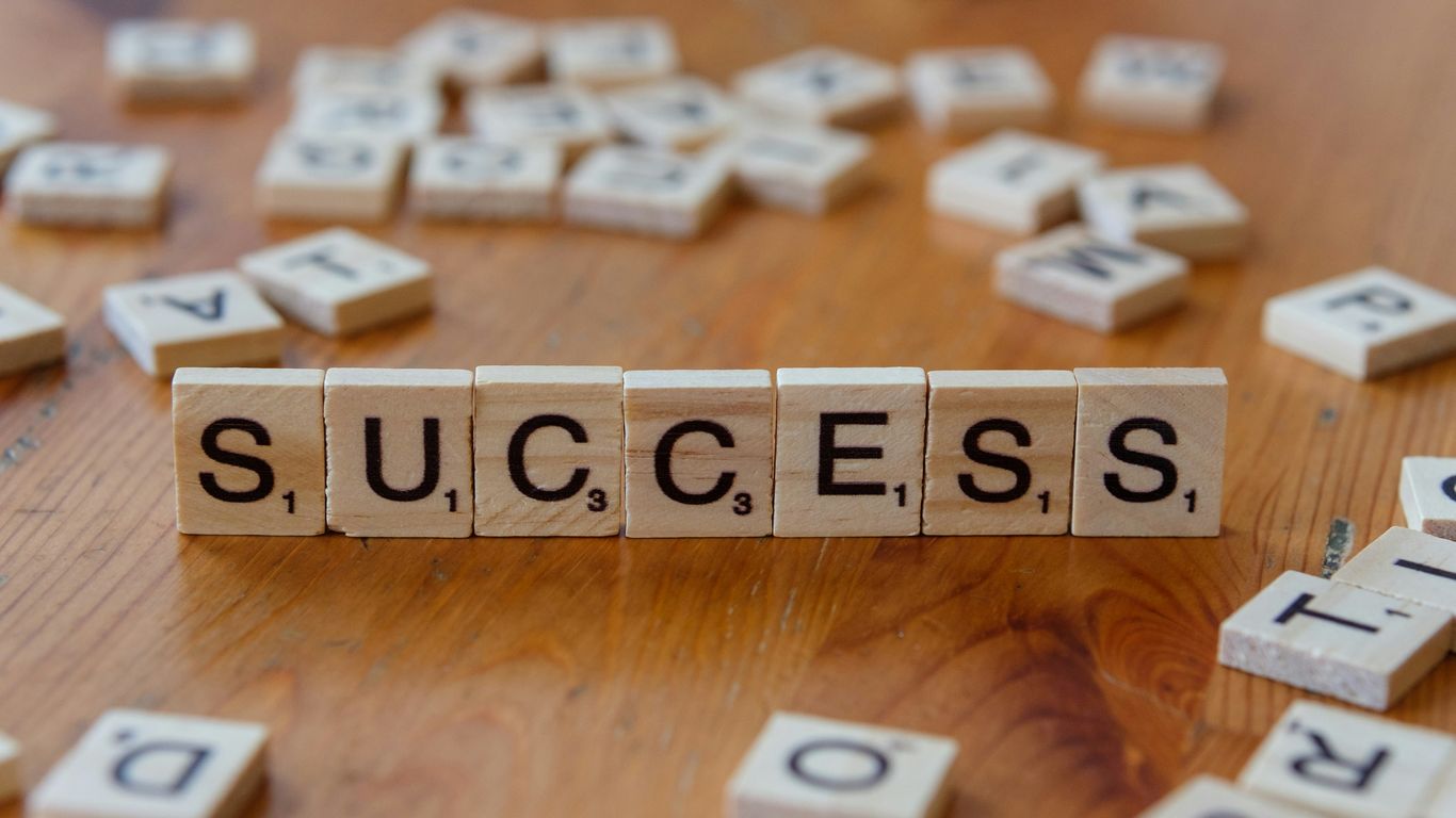 Scrabble tiles spelling out the word success on a wooden table