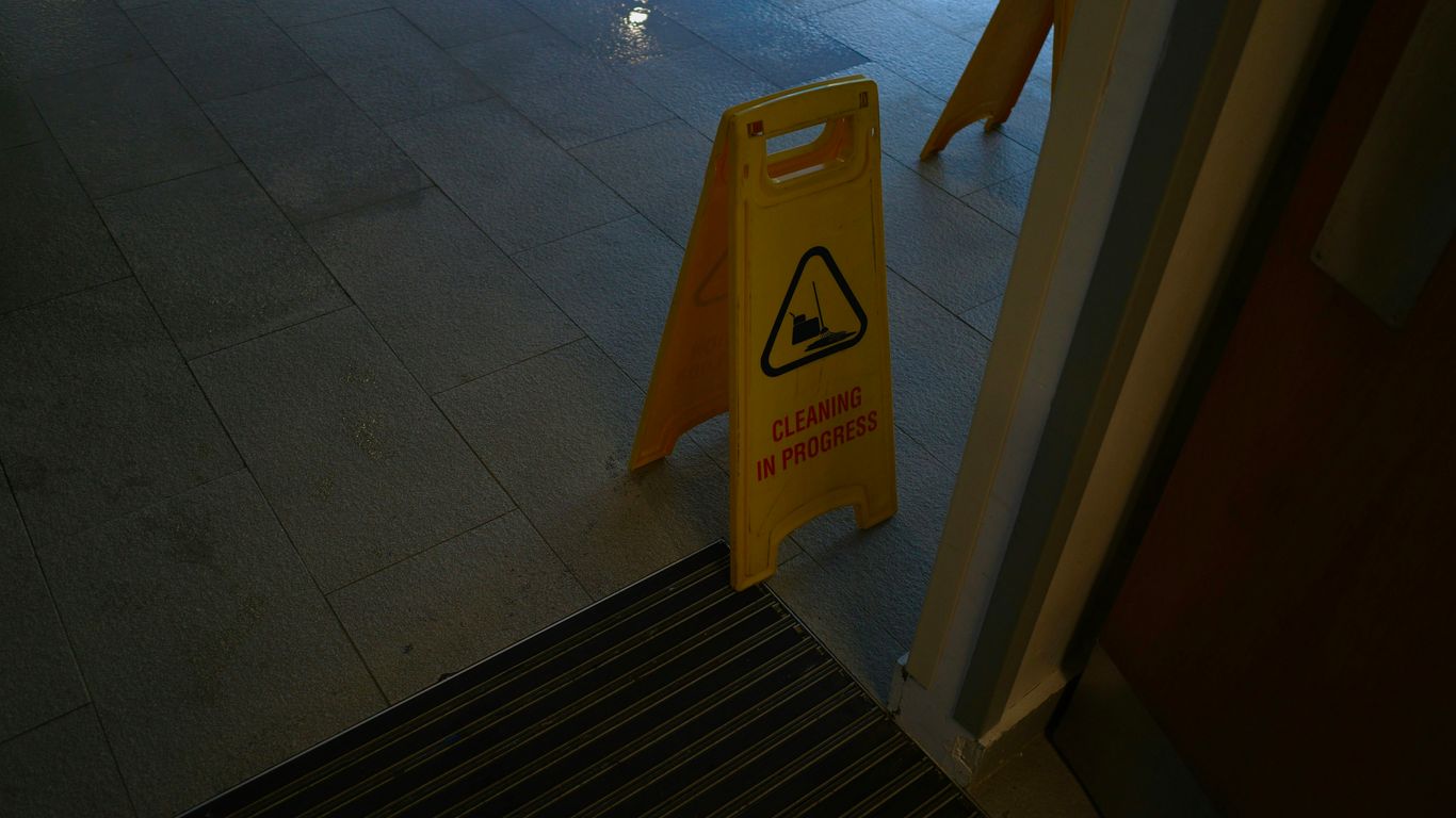 Yellow wet floor warning sign inside doorway